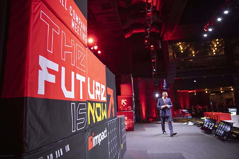 impact executive speaking on stage